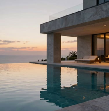 Architectural detail of a luxury villa's infinity pool reflecting the sunset sky. Stone textures in #A9A9A9 and gold-toned pool lighting. Clean, minimal, and aspirational.