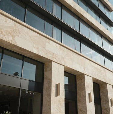 A detailed architectural shot of a luxury building facade in Israel, showcasing clean lines and premium materials like stone and glass.