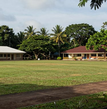 A landscape photograph of the school's outdoor sports area in Calabar, showing clean facilities and lush tropical greenery in the background. The scene is peaceful and well-maintained.
