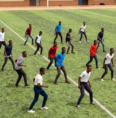 Nigerian students participating in a structured outdoor sport activity on a clean, green school field. High-energy but orderly composition.