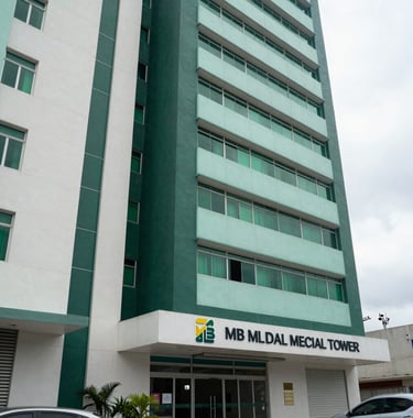 Facade of the MB Medical Tower in Mérida, showing a state-of-the-art medical facility. The architecture is sophisticated, using deep sea green and pale mint white panels. The environment is clean and professional, situated in the premium Temozón North American / Mexican (Yucatán) district.
