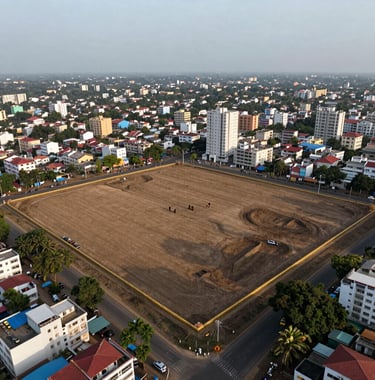 An aerial drone photograph of a clean, cleared land parcel of approximately 1 acre in Chennai. The site is bounded by gold-toned perimeter markings and surrounded by the developing urban sprawl of the Porur area under a clear, light gray sky.