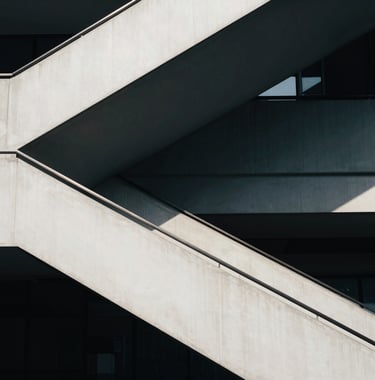 An abstract architectural photograph of a staircase in a modern corporate building, using a palette of dark navy and off-white, with clean lines and sharp shadows, global business style.