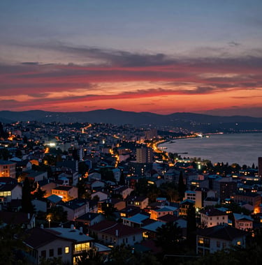 A panoramic sunset view over Trabzon city from Boztepe Hill. The sky is a gradient of dark red and pale blue, with the city lights beginning to twinkle along the Black Sea coast. The composition is professional and atmospheric, highlighting the Eastern European / Turkish architecture.