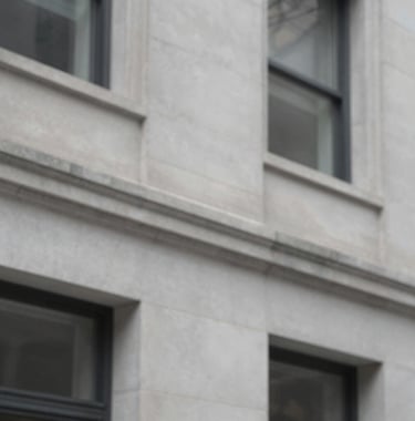 Close-up architectural detail of a modern limestone facade in Streeterville, Chicago. The lighting is crisp, highlighting the clean lines and high-quality materials. Palette includes #EFEFEF and #1A202C shadows.