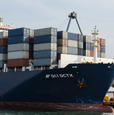 A modern container ship docked at the DCT terminal. The ship's hull is a polished Dark Navy. Stacks of multicolored containers create a geometric pattern of Muted Slate Blue and Soft Steel Grey. The lighting is bright and clear, emphasizing the clean, modern efficiency of the seaport operations.