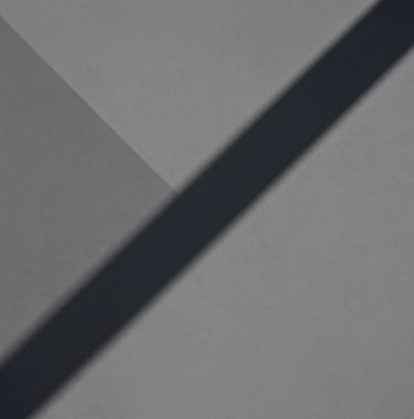 An abstract, editorial photograph of geometric shadows cast upon a matte gray surface. Professional, calm, and architectural, evoking a sense of deep cognitive engagement.