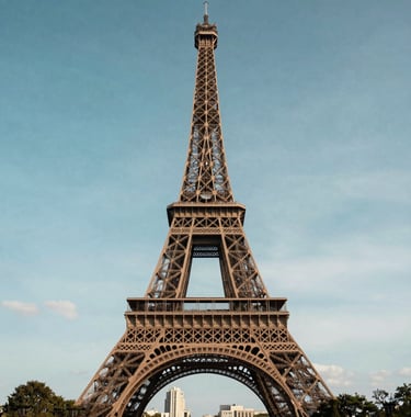 A famous European landmark, like the Eiffel Tower, captured from a distance with a beautiful blue sky background, soft and elegant style.