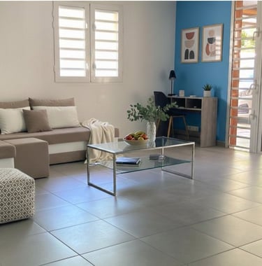 Salon lumineux avec canapé, espace bureau et décoration moderne, loc saisonnière à Ducos Martinique