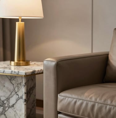 A close-up of a sophisticated Brazilian living room detail. A leather armchair sits next to a marble side table with a gold lamp. Soft lighting, high-end interior design style.