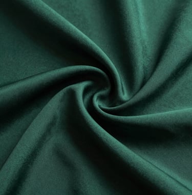 An artistic macro photograph of deep petrol green fabric with elegant, flowing silk textures. Soft studio lighting highlights the curves, evoking a sense of calm and sophisticated transformation.