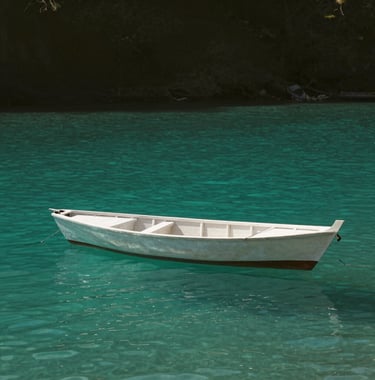 A minimalist, artistic shot of a traditional dhow boat on glass-like turquoise water, creating a tranquil and exclusive atmosphere. Deep olive tones in the distant shoreline. Global / Discerning English-speaking.