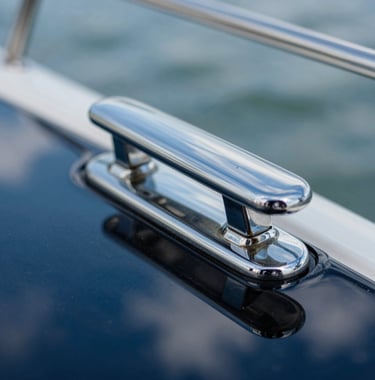 Macro photography showing a perfectly polished chrome cleat and the deep blue reflection of the Florida sky on a flawlessly waxed yacht surface, highlighting the brand's commitment to precision.
