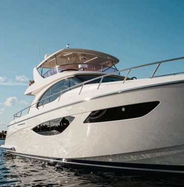 A polished luxury yacht reflecting the clear blue Florida sky, highlighting the perfection of a recent high-end detailing and ceramic coating service.