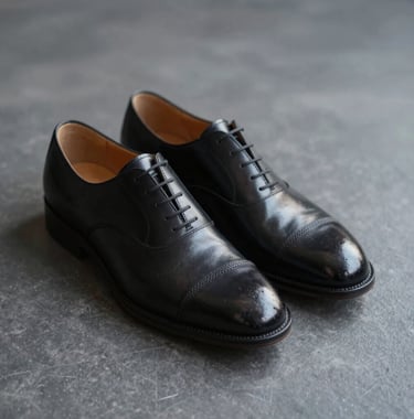 Close up of a pair of high-quality leather oxford shoes on a dark grey floor. Clean, minimalist, sharp focus on texture and craftsmanship.