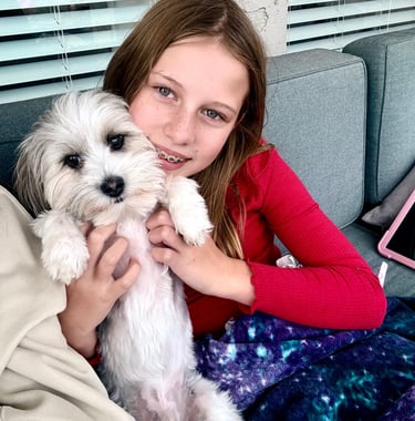 a girl is holding a puppy in her arms