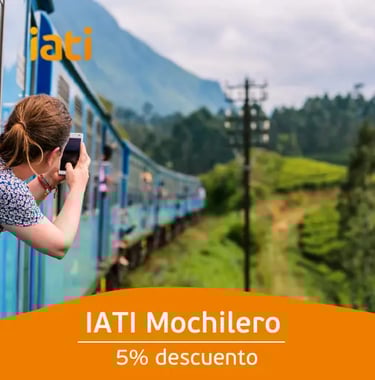 A traveler taking photos from a blue train in Sri Lanka, perfect for backpacker travel insurance.