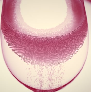 Verre de vin pétillant avec un ourlet de bulles roses