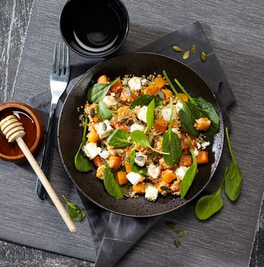 a bowl of food with a wooden spoon and a wooden spoon next to it