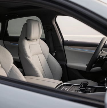 A close-up of a luxurious car interior, premium leather seats, modern dashboard, elegant lighting, professional automotive interior photography.