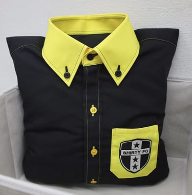 a black pillow designed as shirt with yellow collar and pocket