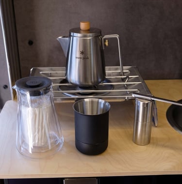 Snow Peak flat burner, kettle, and burr hand grinder, along with a Fellow Stag pour over kit.