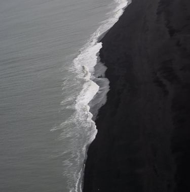 a person walking along a beach with a surfboard