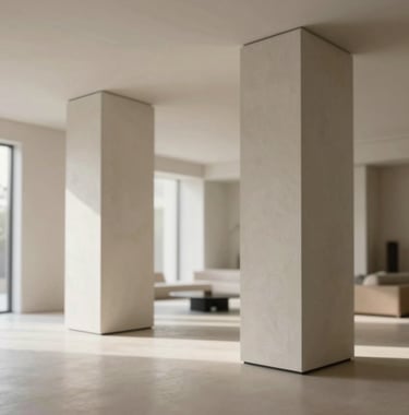 An interior shot of a luxury residential living space showing a focus on safety and integrity with grand, thick structural pillars finished in polished plaster. Minimalist aesthetic, morning light. Brand palette colors #F5F2ED and #C8B8A3 are used throughout.