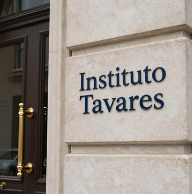 A photograph showing the elegant architectural details of the Instituto Tavares entrance. The door handles are champagne gold, and the sign is engraved in dark navy blue on a warm off-white stone surface.