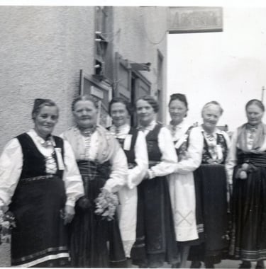 7 women posing in telemark bunad, black and white