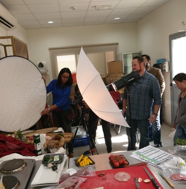 a group of people standing around a table with a camera