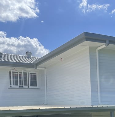 Completed exterior repaint in Zillmere showing bright white house finish under blue sky