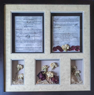Framed wedding shadow box featuring marriage vows, preserved white carnations, and dried rose petals.