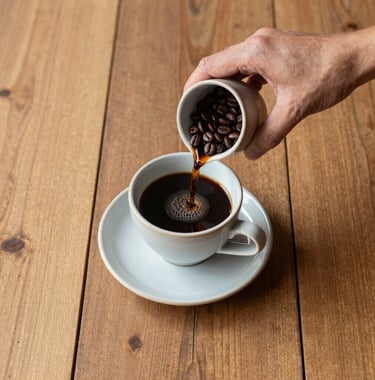 Top-down view of artisanal coffee being served in a ceramic cup on a rustic wooden table in a high-end Brazilian farmhouse, natural light, minimalist style.