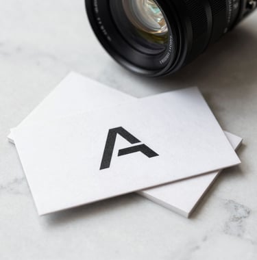 A high-contrast photo of a professional business card with a sleek, minimalist logo on a white marble surface, bright North American corporate lighting.