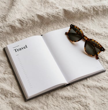 A top-down view of an open travel guide and a pair of tortoiseshell sunglasses on a soft linen cloth of #F8F4EF color. The scene is bathed in natural light, with warm tones of #D3B386 suggesting an elegant, relaxed preparation for a trip.