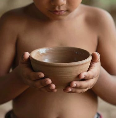 A close-up shot of a child's hands in a South American setting, carefully holding a small clay bowl during a tea ritual. The lighting is warm and organic, highlighting the wabi-sabi texture of the ceramics and the soft skin. Minimalist and aesthetic composition.