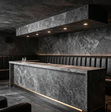 Interior of an exclusive members club, featuring dark leather upholstery, low slate charcoal lighting, and a pristine cool grey bar counter.