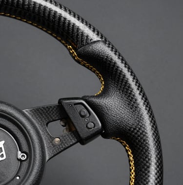 Close-up macro shot of a carbon fiber steering wheel with burnished gold stitching. Sharp focus on the texture of the material with a soft anthracite grey background.