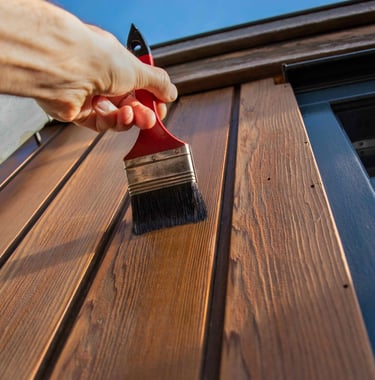 a person is painting a wooden paneled door