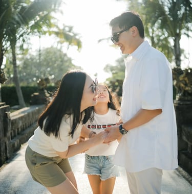 Parents and daughter sharing a playful interaction during a family photography session at InterContinental Bali Resort