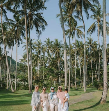 Group of women walking through palm garden during photoshoot at Candi Beach Resort Karangasem Bali