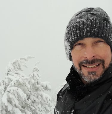 a man in a black jacket and a hat on a snowy day