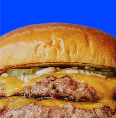 Primer pla d’hamburguesa doble de Flipa amb carn, cheddar fos, ceba i cogombrets