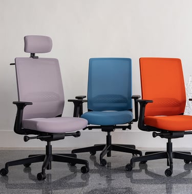 Three ergonomic office chairs in purple, blue, and orange on castors with armrests