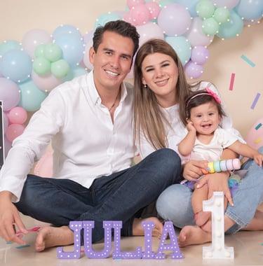 a man and woman sitting on a floor with balloons
