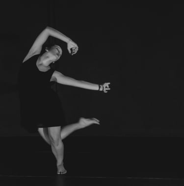 a woman in a black dress is dancing in a black and white photo