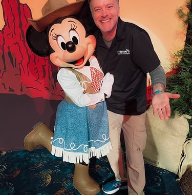 Minnie's Travel Boutique co-owner Chris Breedlove pictured with Minnie Mouse at The Disneyland® Hotel.
