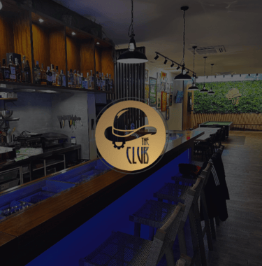  Interior de club cannábico con barra iluminada y logotipo redondo the club
