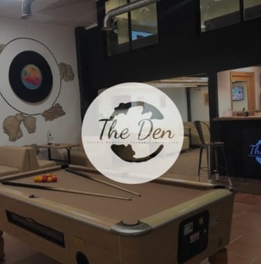 Interior de The Den Cannabis Club con mesa de billar y logotipo